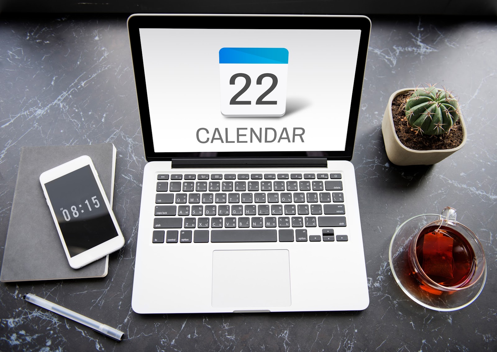 An image of a phone and a laptop with time and calendar date.